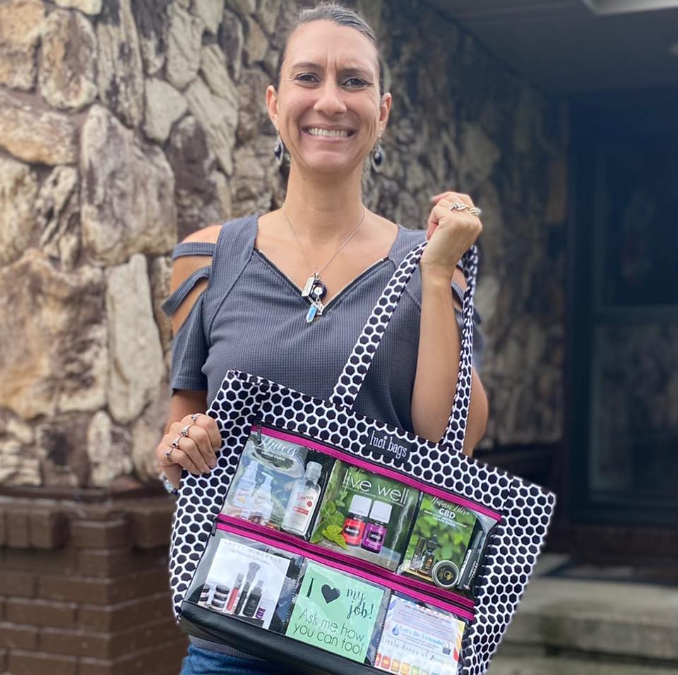 Luci Bags affiliate, Jen holding a large tote to display her oil business.